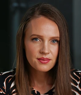 Rachel Rasmussen in a black, rust, and cream patterned shirt